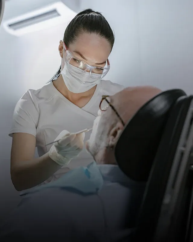 A dental professional cleaning a patient's mouth during a dental appointment